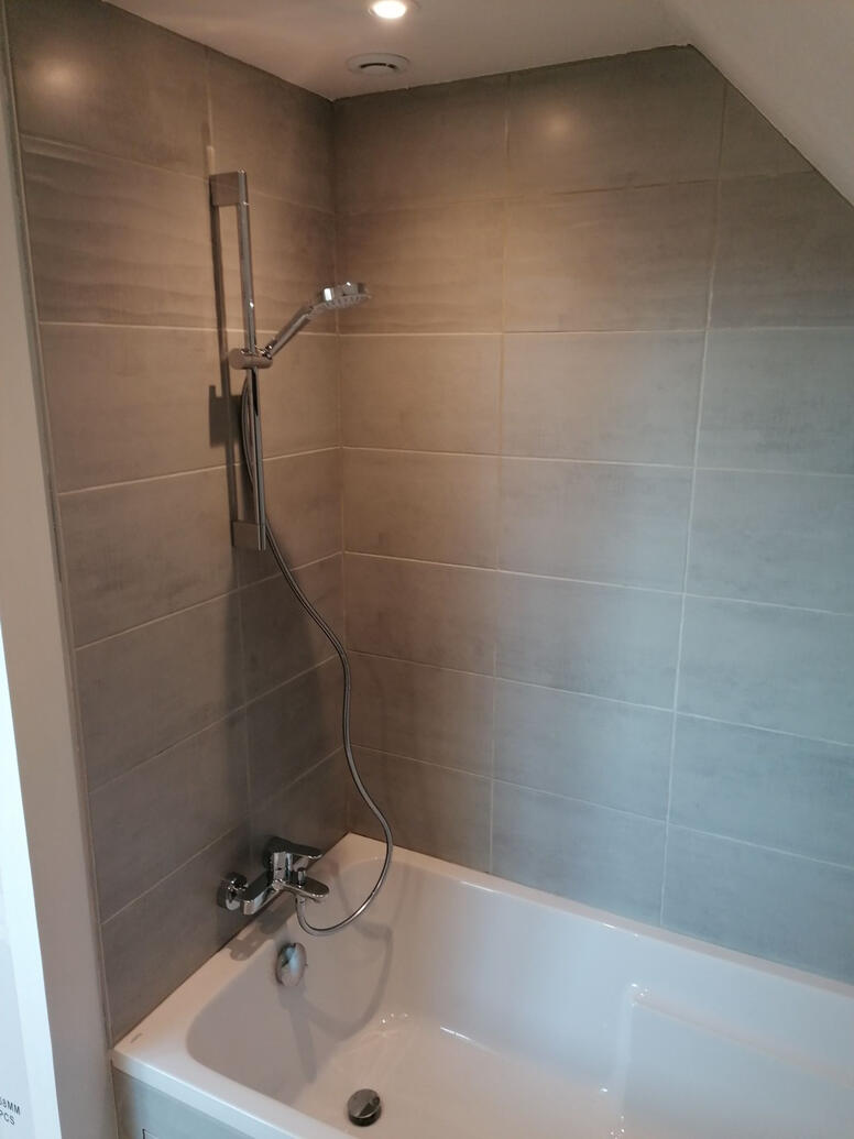 baignoire sous-pente carrelée avec colonne de douche